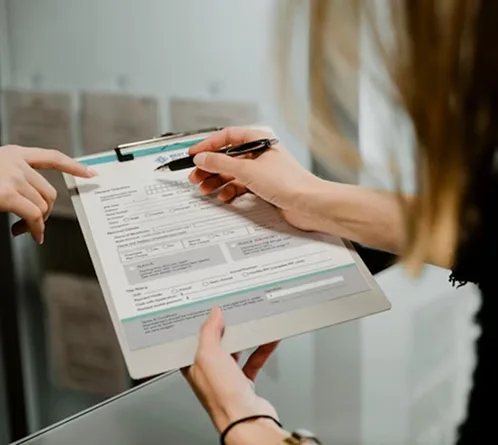 Persona firmando documentación de comercio exterior sobre una carpeta