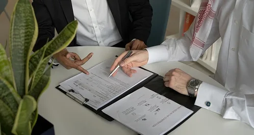 Dos personas revisando documentación sobre un escritorio