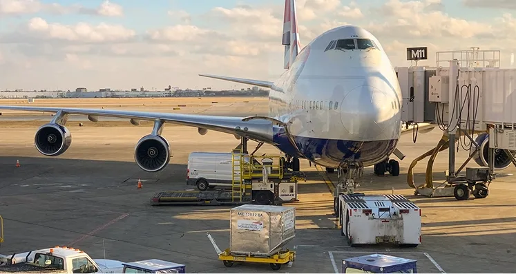 Avión carguero en plataforma junto a equipos de carga